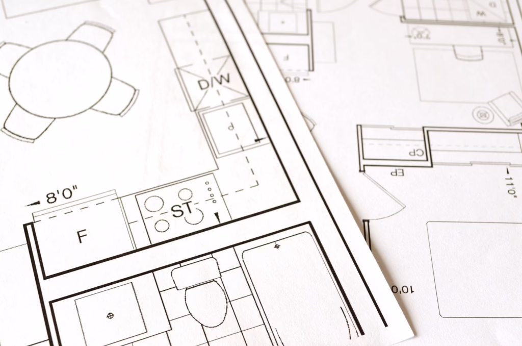 Plano arquitectónico con boceto y herramientas de dibujo